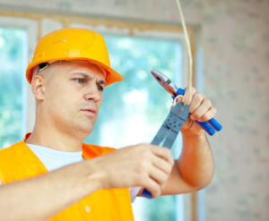 Electrician holding pliers and electrical wire